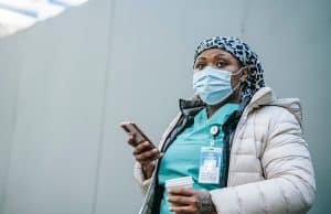 nurse in mobile phone in scrub suit